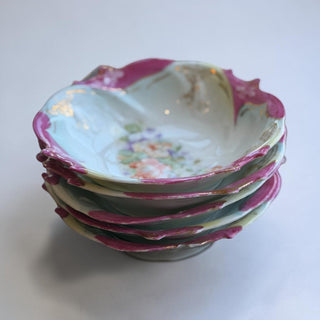 Her Good Eye antique porcelain serving bowl with floral motif, scalloped rim, and gold detailing. Pastel blue, peach, coral, lavender, and magenta colors.