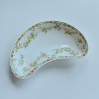 Her Good Eye antique kidney-shaped porcelain serving dish with pink and purple floral accents and green vine border.