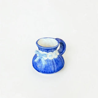 Her Good Eye ceramic creamer pitcher in deep blue with white scalloped trim and a dainty bow accent.