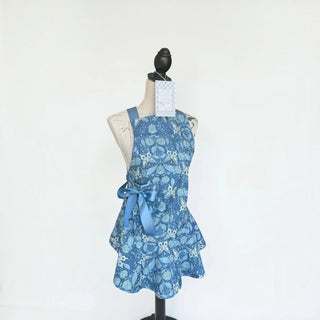 Her Good Eye blue floral print kitchen apron with satin ribbon side bow on a mannequin