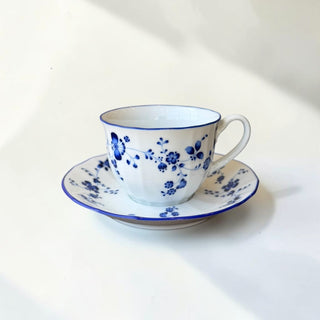 Her Good Eye blue floral porcelain teacup and saucer set with scalloped edges and blue rim.