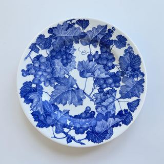 Her Good Eye blue grape vine pattern ceramic dinner plate with intricate detailing on a white background.