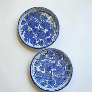 Her Good Eye blue and white ceramic serving dish with scalloped edge and intricate floral and gourd pattern.