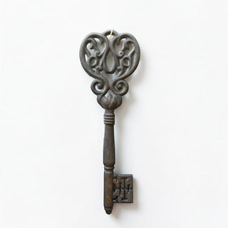 Her Good Eye decorative cast iron skeleton key with ornate scrollwork and a rustic dark finish for wall decor.