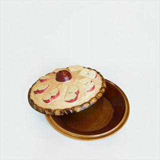 Her Good Eye ceramic apple pie serving dish with a whimsical lid featuring hand-painted apple slices and brown base.