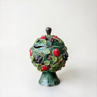 Her Good Eye decorative ceramic lidded jar with emerald green glaze, sculpted apples, grapes, and leaves. Features a dark wood knob.