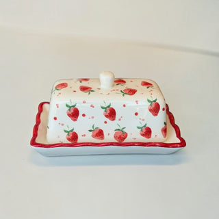 Her Good Eye hand-painted ceramic butter dish with a white base, red strawberry pattern, and scalloped red trim.