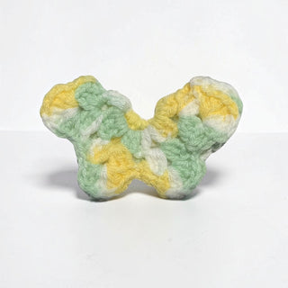 Her Good Eye handmade crochet butterfly hair clip in variegated pastel yellow, mint green, and white yarn.