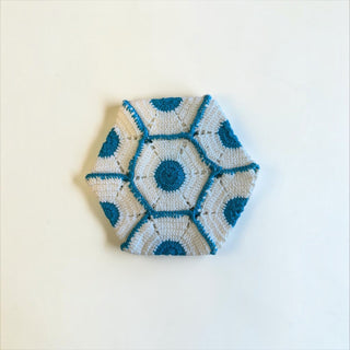 Her Good Eye handmade crochet hexagon coaster in white and teal yarn with geometric stitch pattern