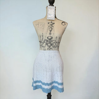 Her Good Eye white crochet mini skirt with blue trim and open-knit pattern. Adjustable tie-back closure.