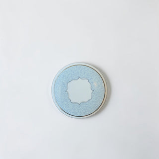 Her Good Eye decorative round tin with ornate center, pale blue with textured pattern and gold trim.