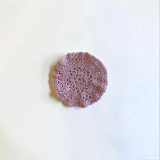 Her Good Eye dusty rose handmade cotton crochet coaster with an intricate floral pattern on a white background.