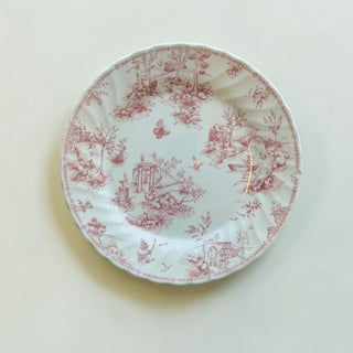 Her Good Eye dusty rose porcelain dinner plate with vintage toile de jouy pastoral pattern and scalloped edges.