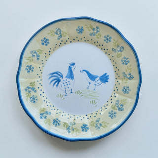 Her Good Eye farmhouse rooster and hen decorative plate, yellow ceramic with blue floral motifs and scalloped edge.