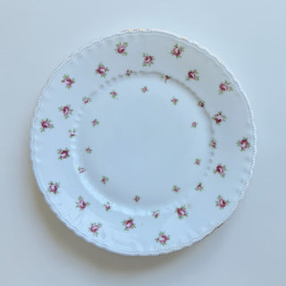 Her Good Eye white porcelain dinner plate with scattered pink roses, beaded edge, and gold trim.