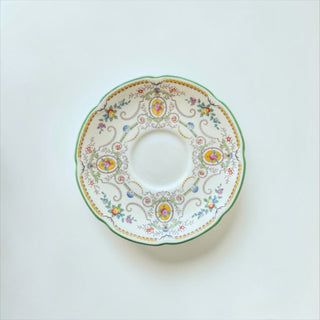 Her Good Eye vintage-style porcelain saucer with scalloped edge, green trim, and ornate floral pattern.