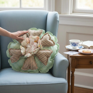 Her Good Eye flower-shaped throw pillow with mint green geometric petals, lace center, and scalloped edges on a chair.