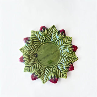 Her Good Eye glossy green ceramic plate with embossed leaf pattern and red strawberry accents on scalloped edges.