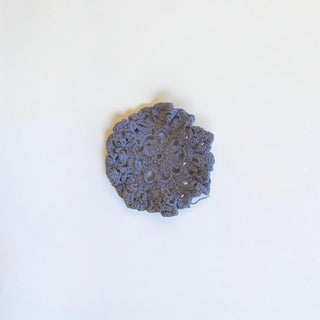 Her Good Eye handmade grey crochet coaster with an intricate circular floral pattern made from soft cotton yarn.