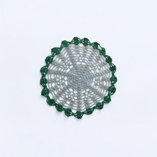 Her Good Eye handmade crochet doily with a grey center and deep forest green scalloped lace border.