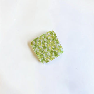 Her Good Eye handmade square crochet drink coaster in a lime green and white checkerboard pattern.