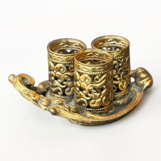 Her Good Eye antique gold metal triple candle holder tray with intricate filigree patterns on a white background