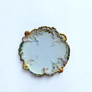 Her Good Eye ornate porcelain serving plate with scalloped edges, floral motifs, and gilded gold accents.