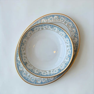 Her Good Eye oval serving dish in white porcelain with blue floral pattern and gold rim. Perfect for elegant dining.