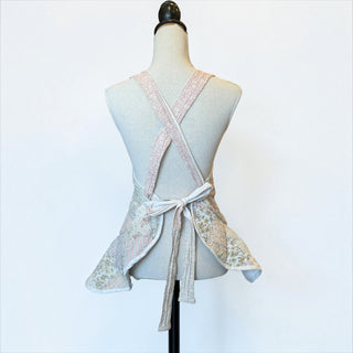 Her Good Eye vintage style patchwork floral kitchen apron with cross-back straps on a mannequin, back view.