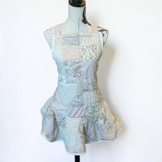 Her Good Eye vintage style patchwork cotton apron with pastel floral, gingham, and paisley prints on a mannequin.