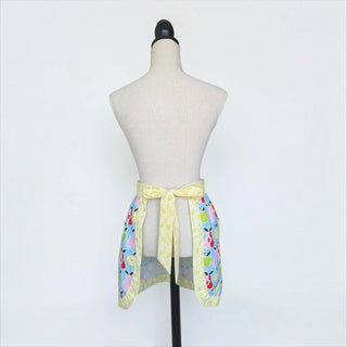 Her Good Eye kitchen waist apron in blue cotton with a colorful pear print and yellow floral trim on a mannequin.