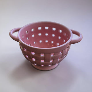 Her Good Eye pink ceramic colander with handles and basketweave pattern. Perfect for kitchen use.