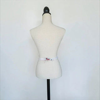 Her Good Eye vintage style white half apron with red and navy polka dots and a tied waist on a mannequin