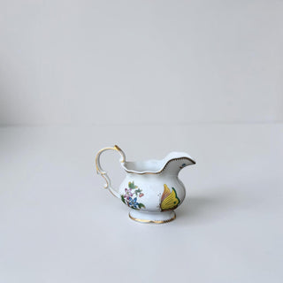 Her Good Eye porcelain creamer with hand-painted butterfly and floral motifs, gold-tone trim, and elegant handle.