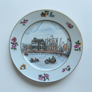 Her Good Eye decorative porcelain plate with harbor scene, sailing ships, floral accents, and gold trim.