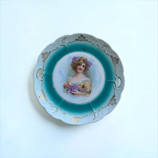 Her Good Eye vintage porcelain plate with woman portrait, purple flowers, teal border, and gold filigree scalloped edge.