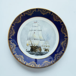 Her Good Eye porcelain collector plate featuring a historic tall ship with a cobalt blue border and gold filigree.