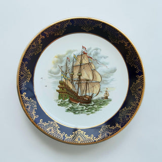 Her Good Eye porcelain collector plate featuring a historic tall ship, cobalt blue border, and gold filigree detailing.