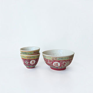 Her Good Eye hand-painted porcelain tea cups featuring magenta, yellow, and teal floral motifs and geometric borders.