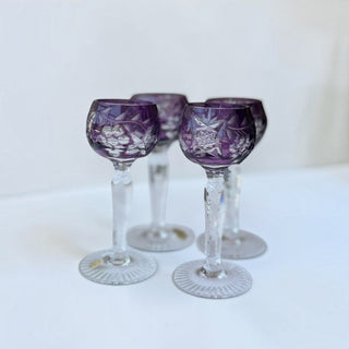 Her Good Eye set of four vintage purple cut crystal cordial glasses with intricate starburst and floral motifs.