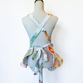 Her Good Eye vintage quilted hexagon patchwork apron with ruffled hem and cross-back straps on a mannequin