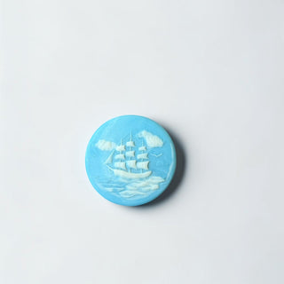 Her Good Eye sky-blue round trinket dish with bas-relief sailing ship motif and marbled interior.