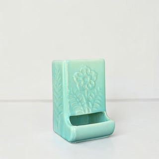 Her Good Eye seafoam green ceramic matchstick holder with embossed floral design and glossy finish.