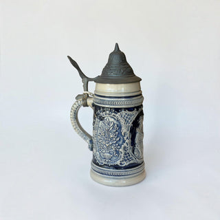 Her Good Eye traditional German stoneware beer stein with cobalt blue relief floral motifs and a pewter hinged lid.