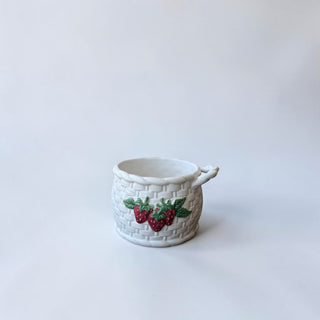 Her Good Eye white ceramic mug designed like a basket with embossed strawberries and green leaves.