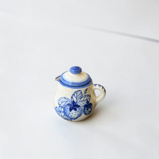 Her Good Eye hand-painted ceramic creamer pitcher with blue strawberries and green leaves on an ivory background.