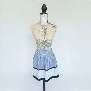 Her Good Eye blue and white striped waist apron with navy trim on a vintage-style mannequin.