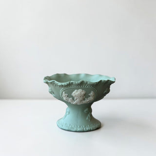 Her Good Eye matte teal ceramic pedestal bowl with cameo embellishment and scalloped rim.