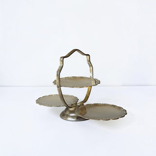Her Good Eye vintage-inspired tiered metal serving stand with ornate scalloped edges and a metallic finish.