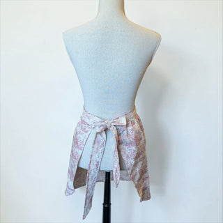 Her Good Eye vintage-inspired half apron in dusty rose toile print with delicate lace trim on a mannequin
